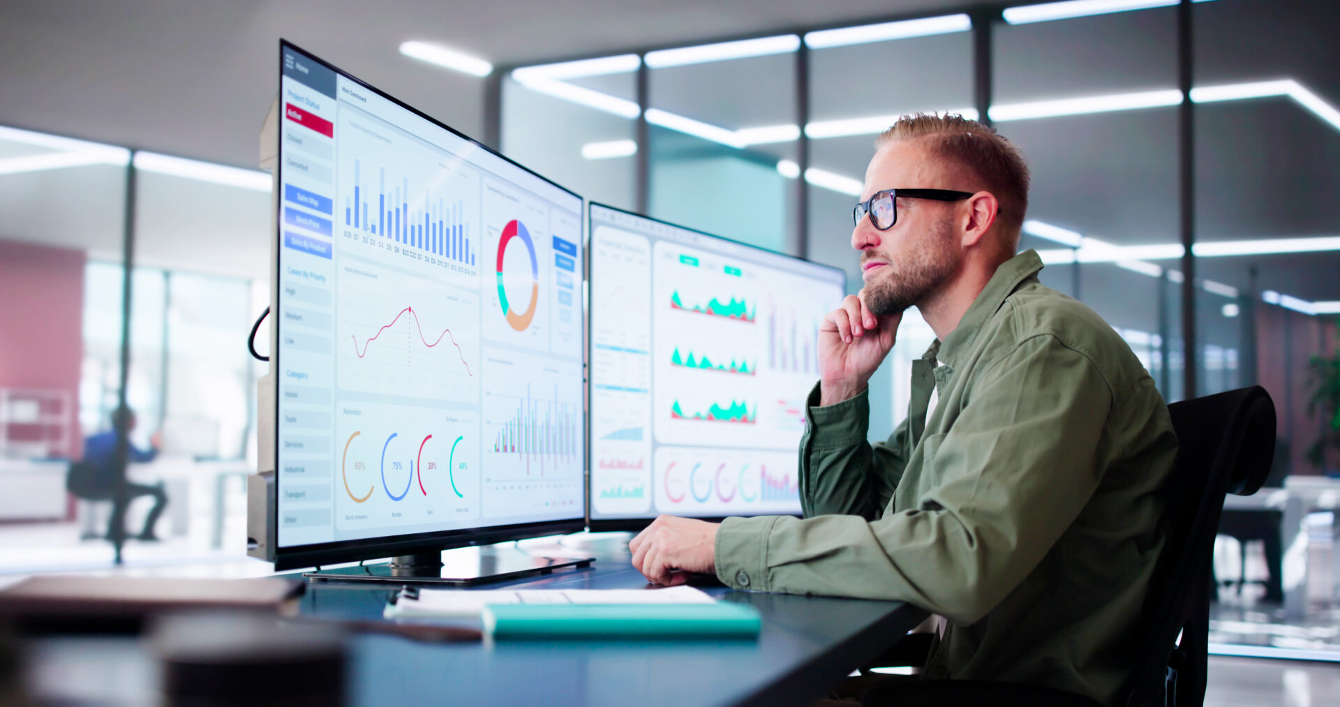 Man analyzing data on multiple computer screens
