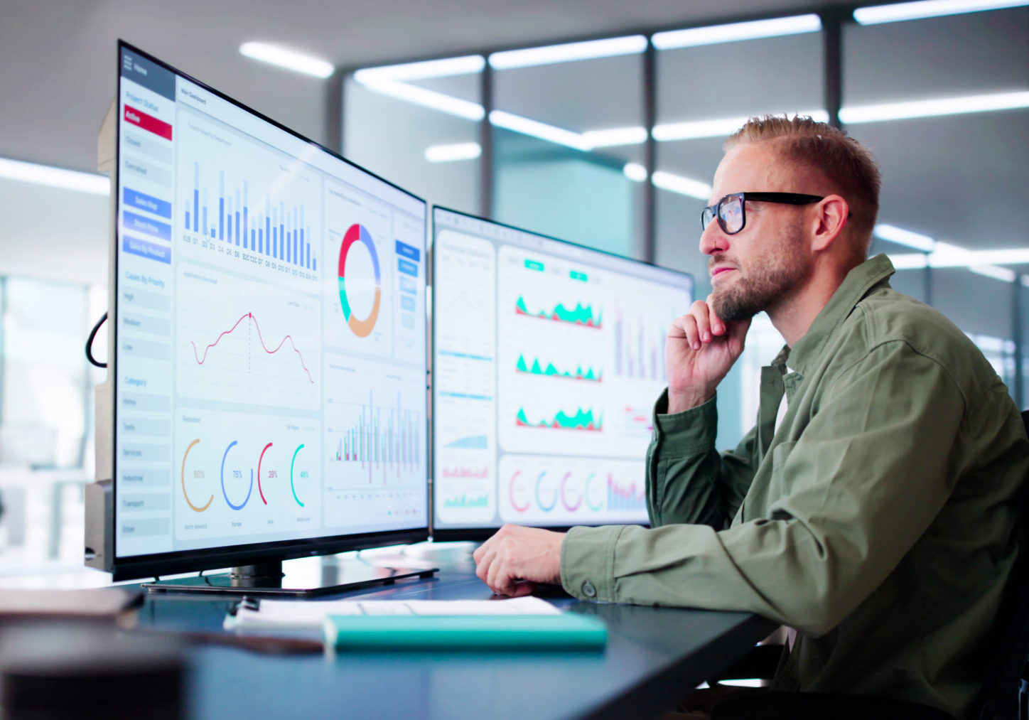 Man analyzing data on multiple computer screens